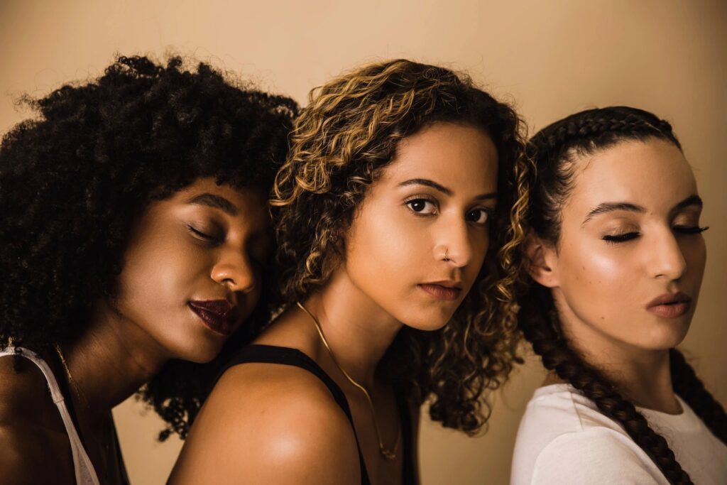 three women standing facing their right.